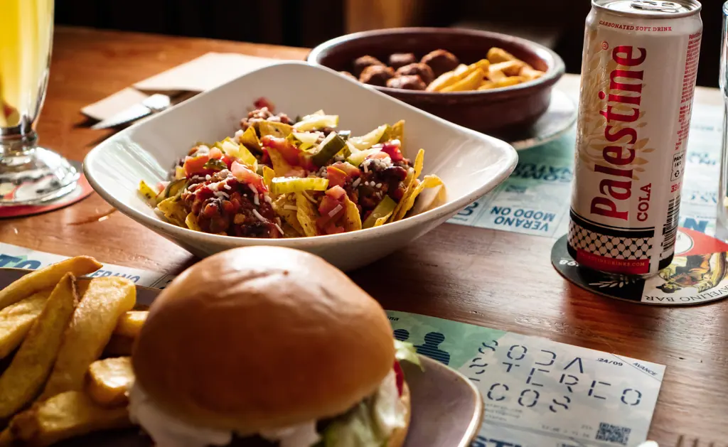 Nachos con chili, albóndigas con patatas y una hamburguesa vegana en una mesa de Viva Chapata